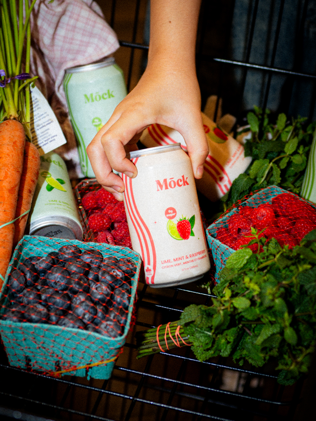 Mōck among fresh berries and produce at the market