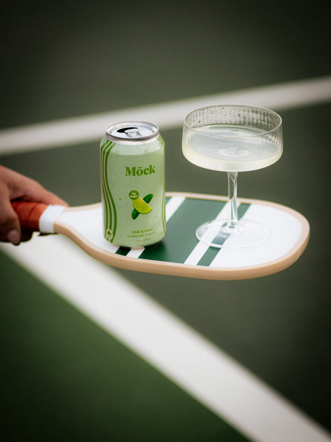 Mōck Lime & Mint on a pickleball paddle courtside