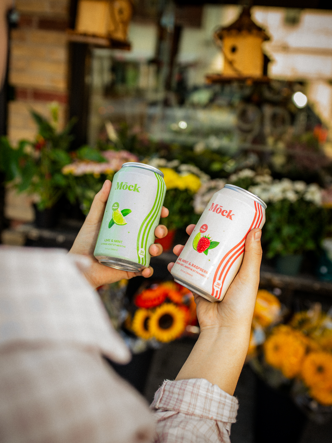 Two Mōck cans in front of a flower shop